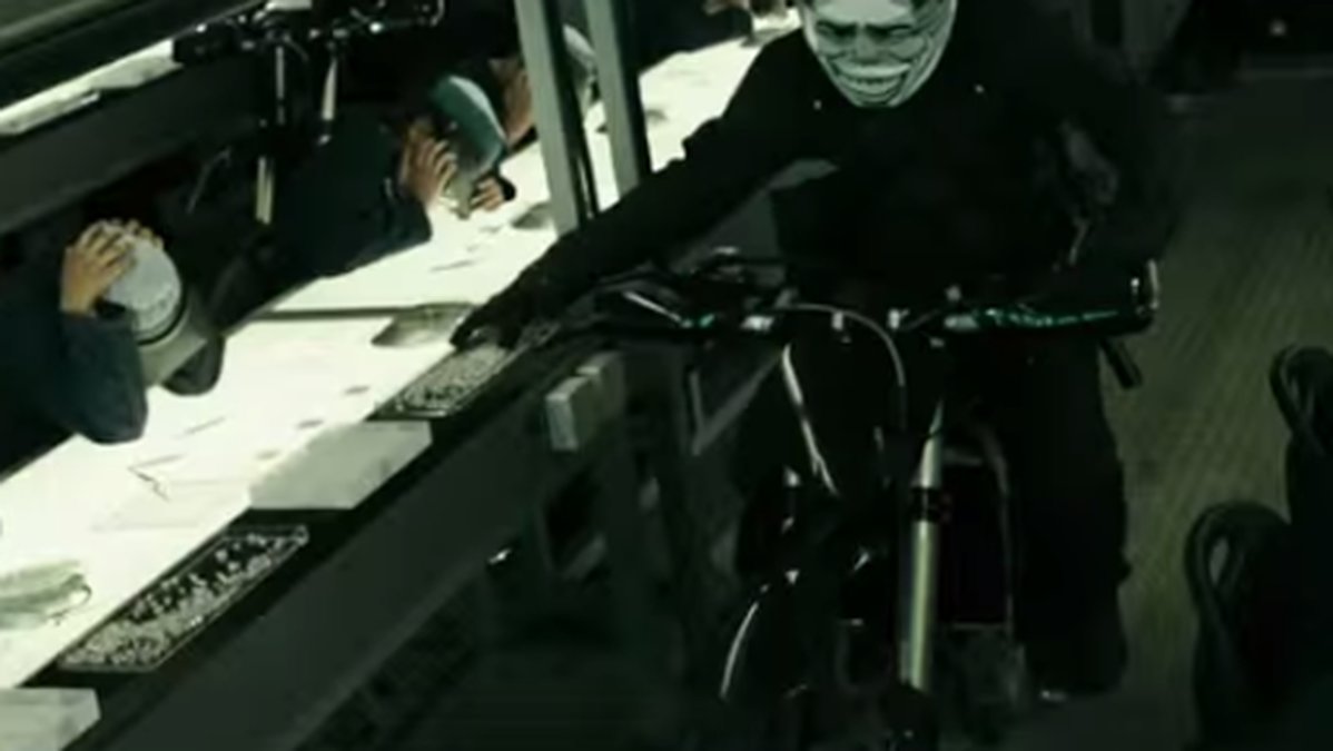 En maskerad man drar in på sin hoj under ett rån som vi får se i trailern.